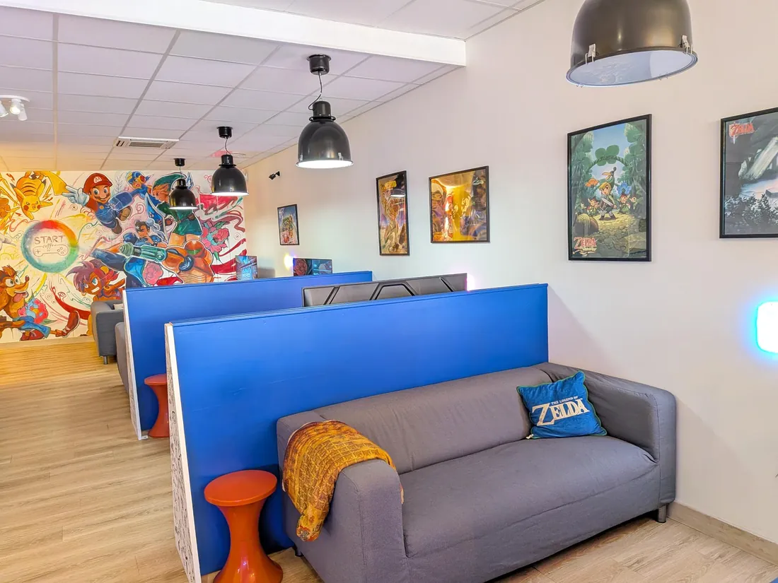Canapé gris et coussin Zelda dans une alcôve de jeu bleue
